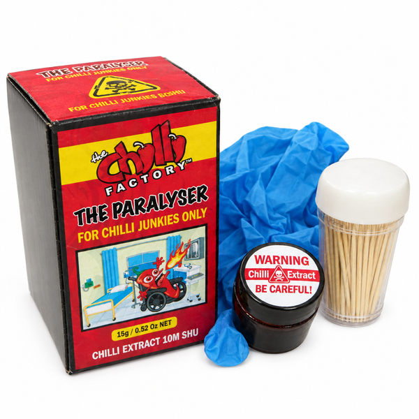 The Paralyser chilli extract kit by The Chilli Factory, including a red and black product box, a small jar of chilli extract with a warning label, a plastic cup of toothpicks, and a blue nitrile glove, all on a white background. Buy online at Deathsauce Australia.